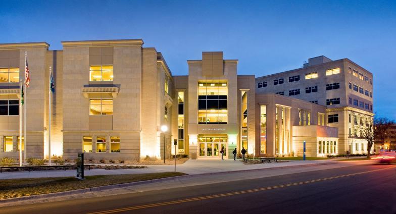 Ricahrd H. Barry Hall, a large building of light-colored cut stone, is pictured at night. 