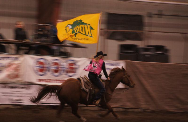 一名女子在竞技场上骑着马，身上挂着新苏党旗
